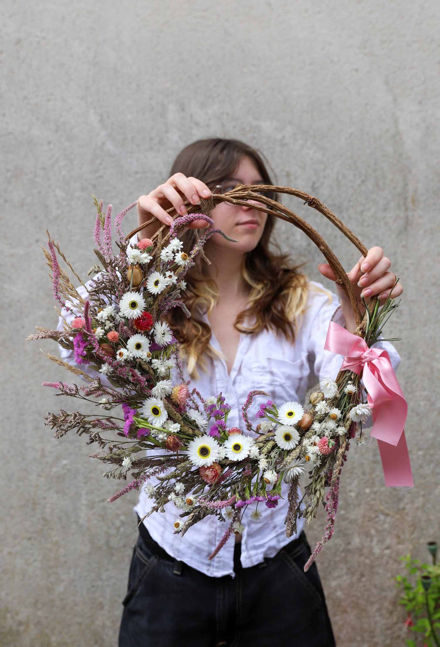 grande couronne fournie de fleurs séchées naturelles avec du ruban et des sarments