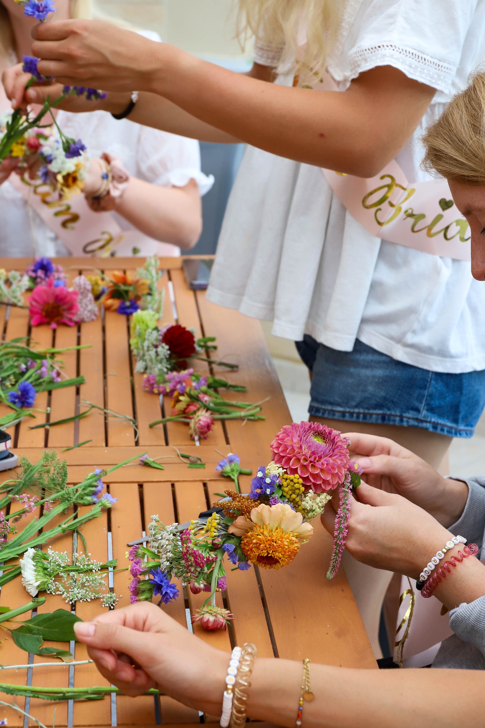 atelier floral entre amies en Baie de Somme. La future mariée et ses amies confectionnent une couronne de fleurs