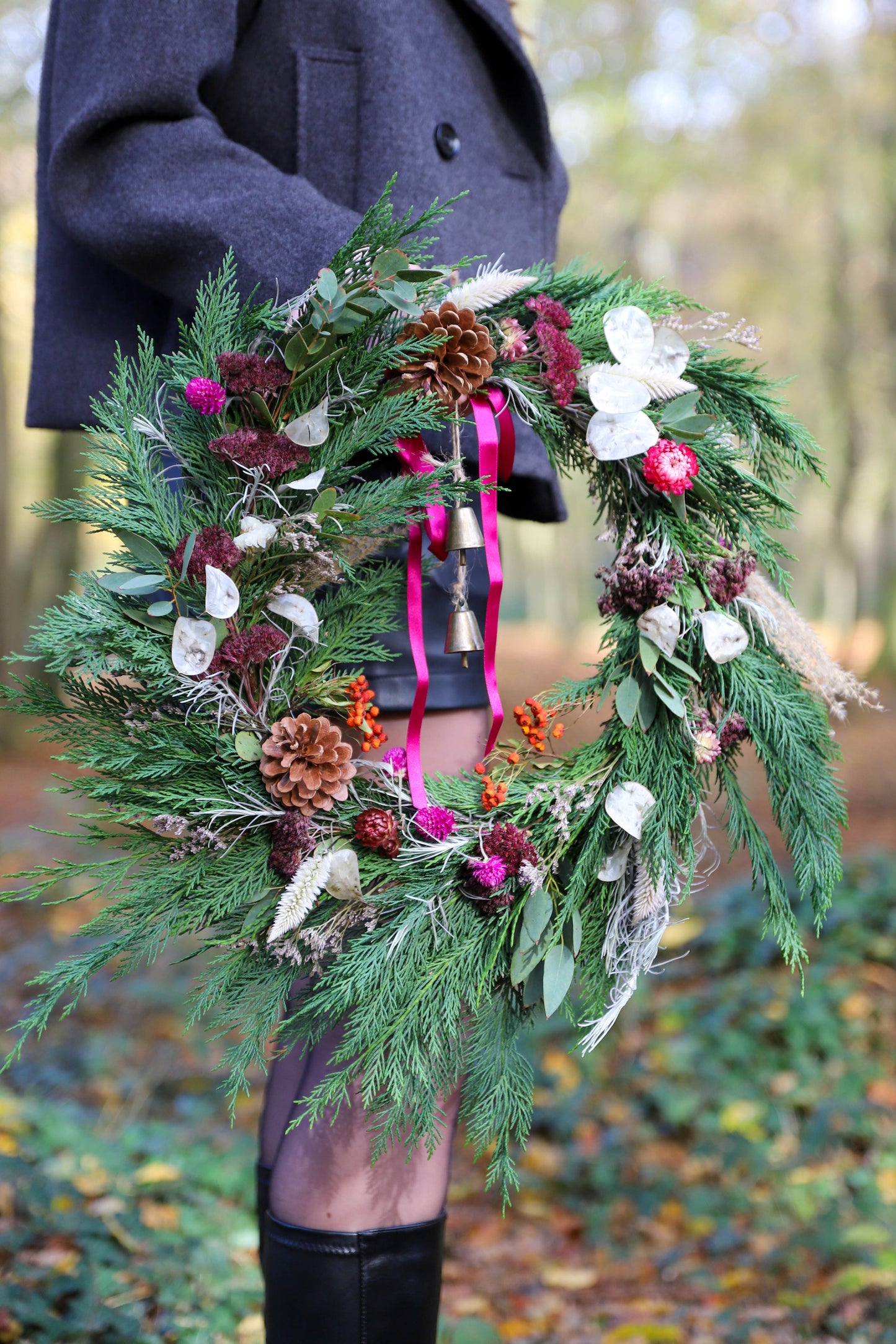 Couronne de Noël réalisée avec des branches de sapins et des fleurs séchées françaises. La couronne est colorée et de bonne qualité