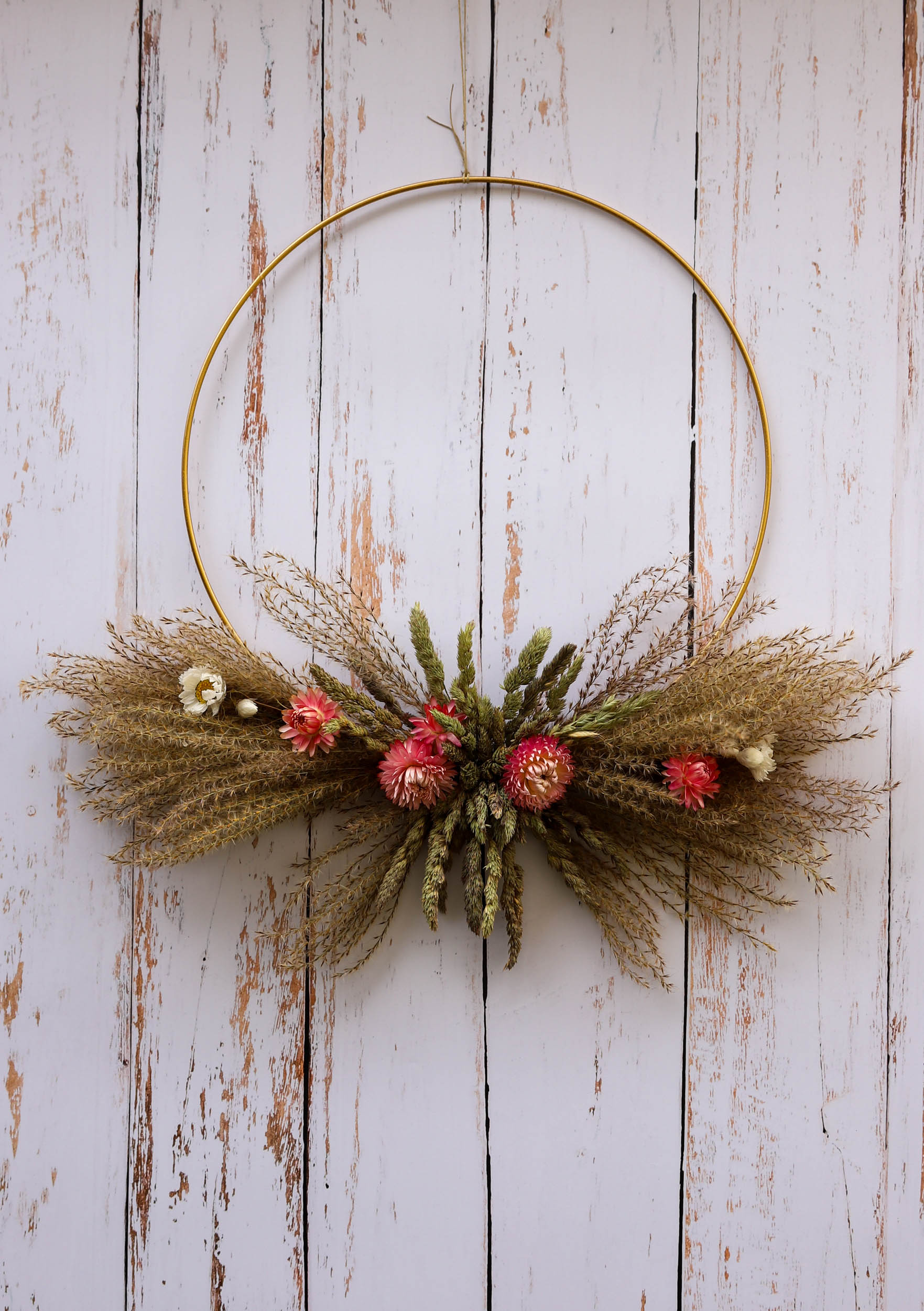 couronne de fleurs séchées rose pâle avec des graminés et des miscanthus