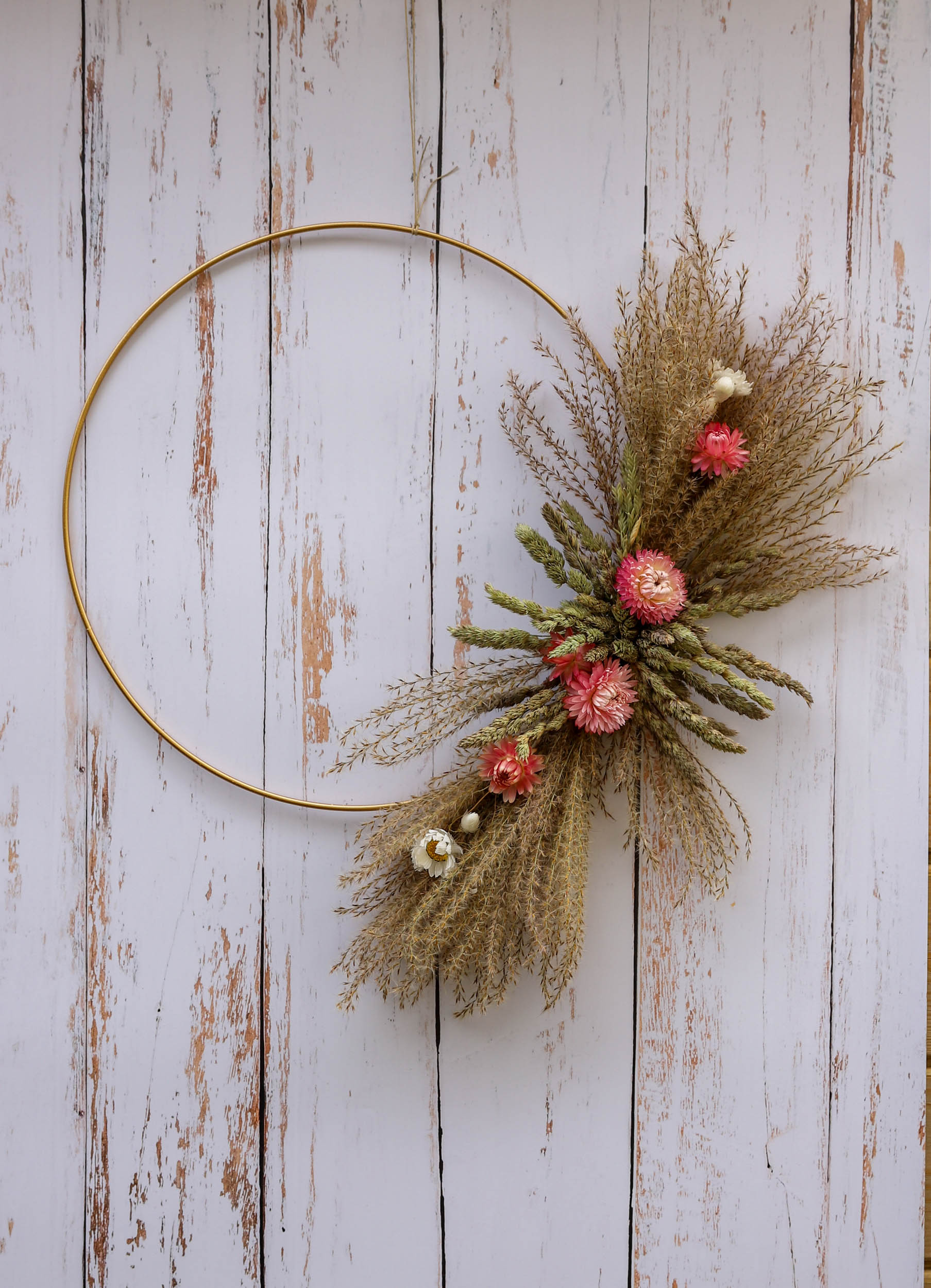 couronne de fleurs séchées avec des plumeaux et des immortelles roses