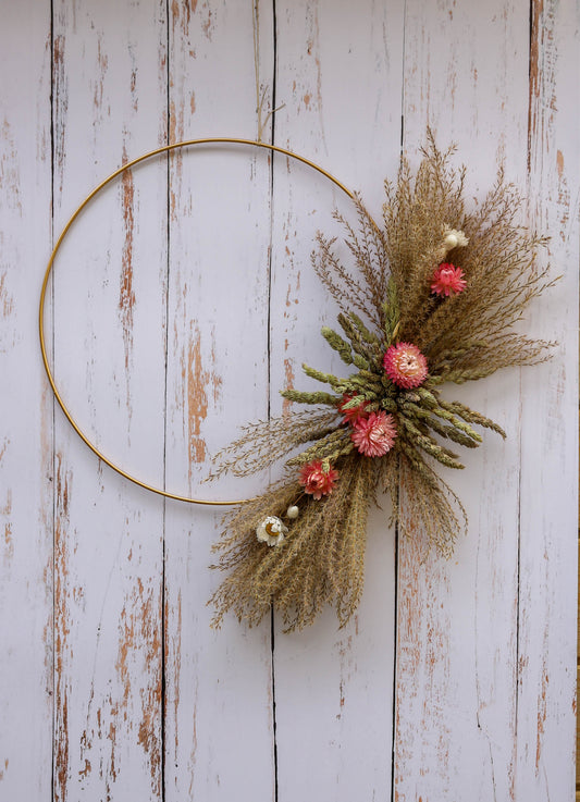 couronne de fleurs séchées avec des plumeaux et des immortelles roses